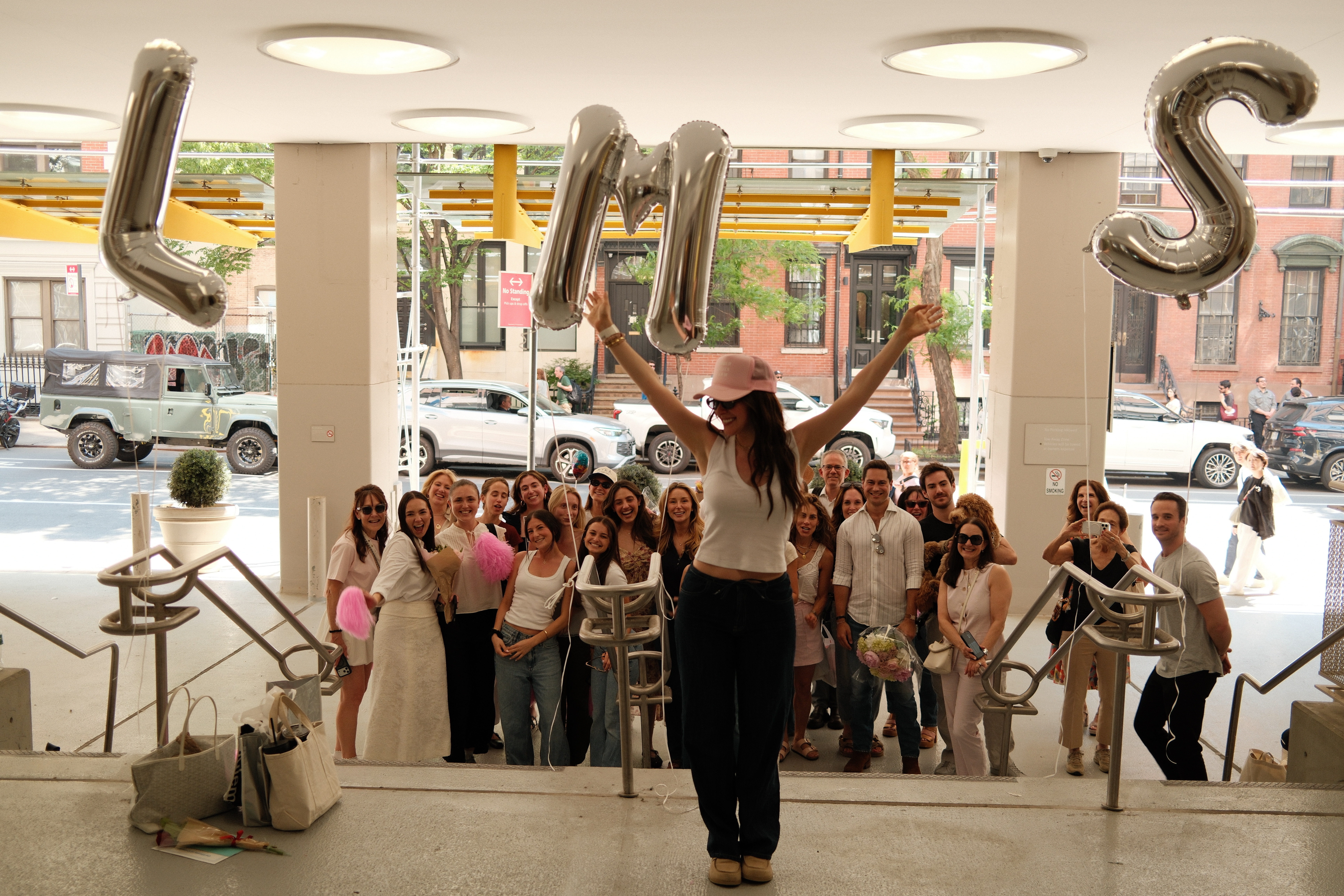 girl standing in front of her friends at the hospital after finishing breast cancer treatment