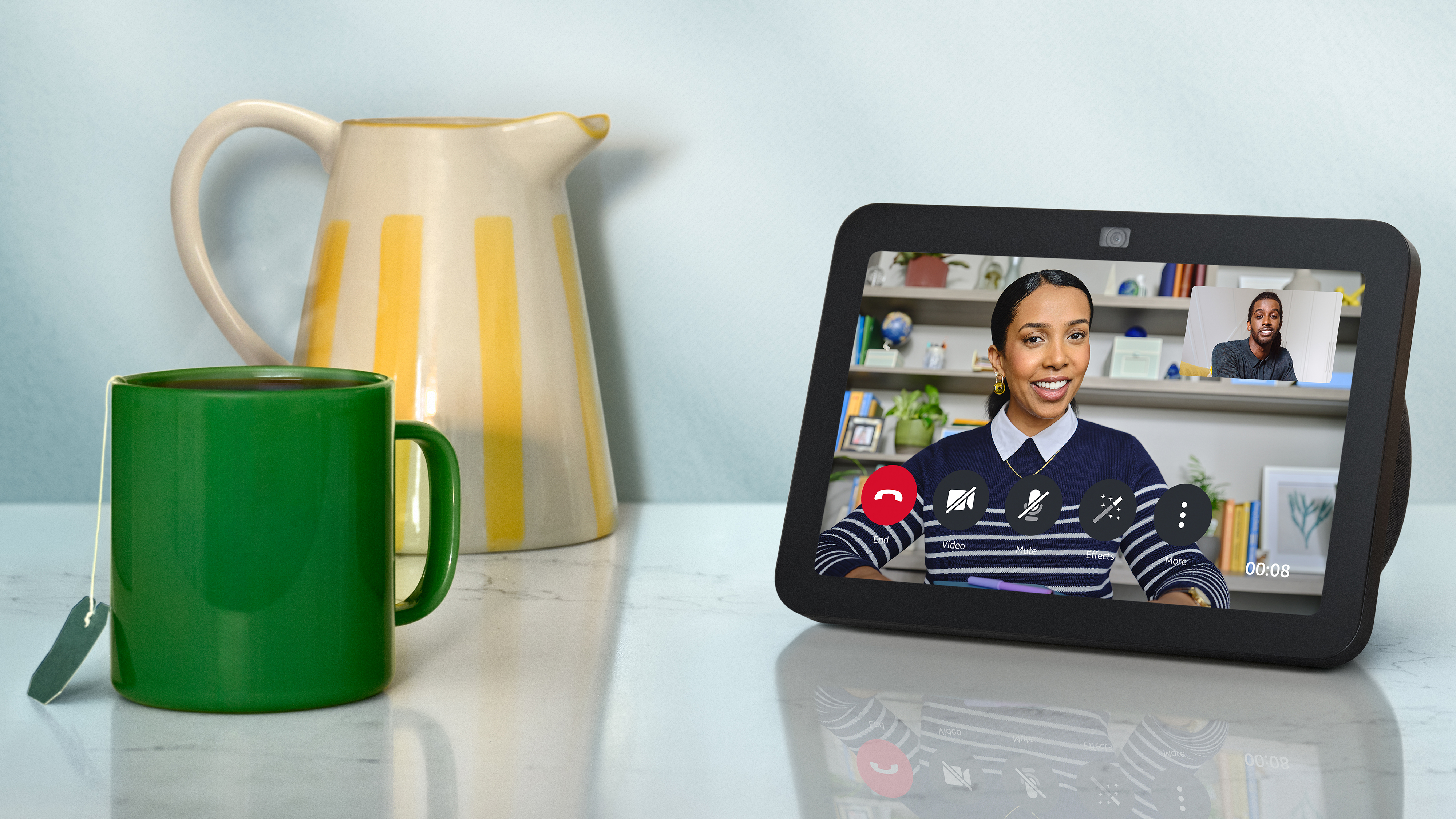 The Amazon Echo Show 8 on a table next to two jugs