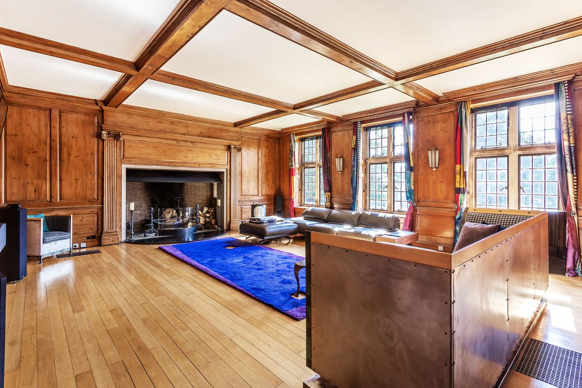 A sitting room with a fireplace and long blue carpet