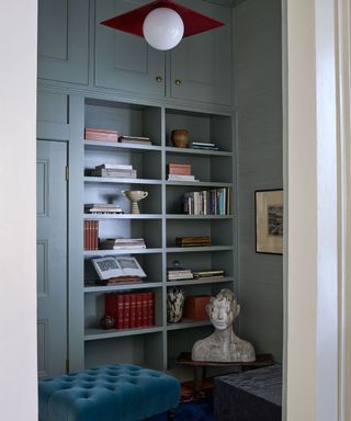 blue study with book shelves and a pop of red with a modern ceiling light