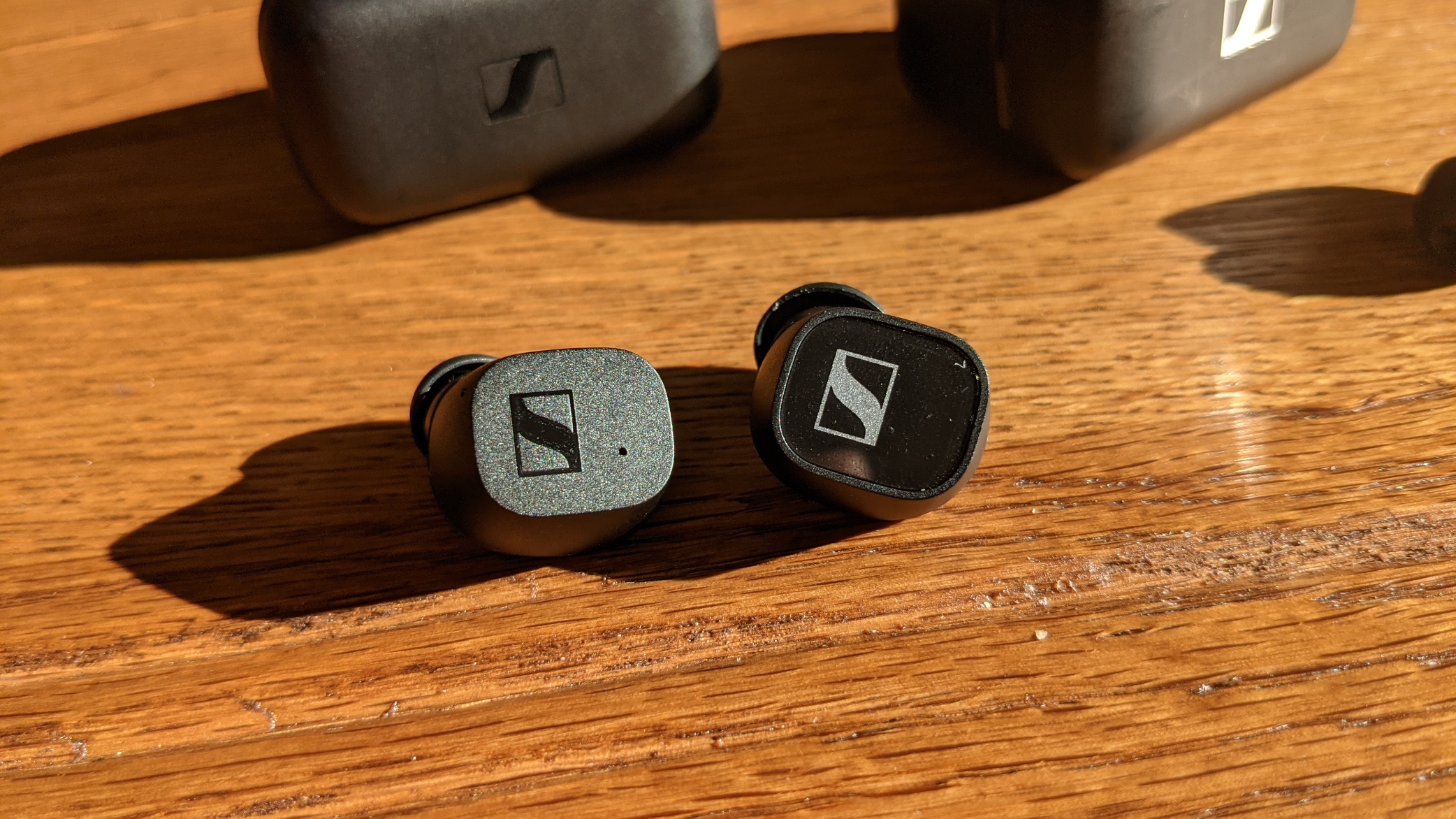 Sennheiser CX True Wireless links und Sennheiser CX 400BT mit Cases nebeneinander auf einem Tisch