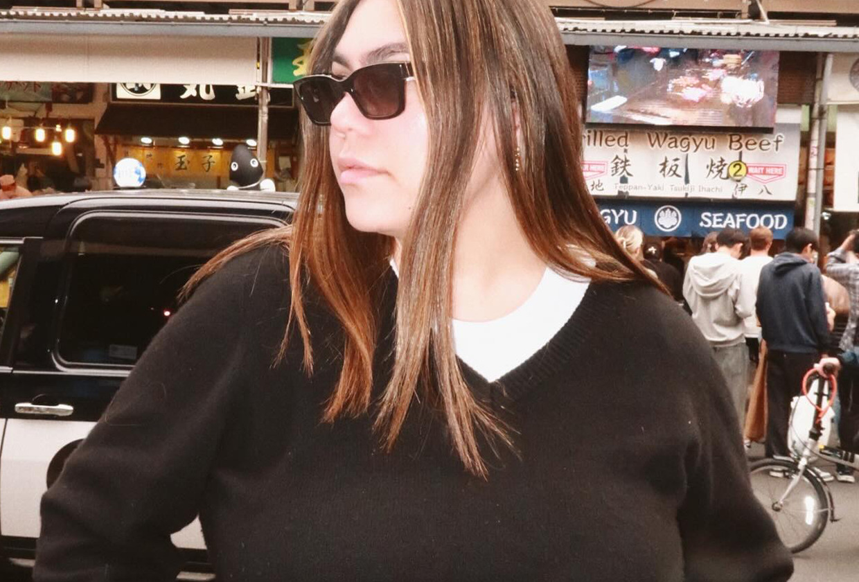 Who What Wear editor Ana Escalante wears white plus-size t-shirt and black plus-size sweater while posing on street.