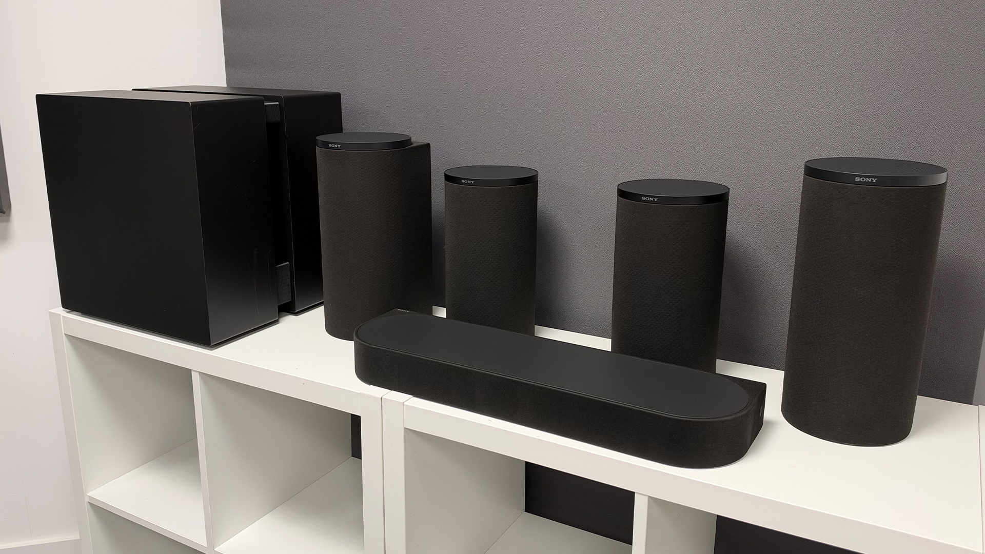 Sony Bravia Theatre Trio + Rear 9 and Sub 9 surround sound system on white shelving unit in test room