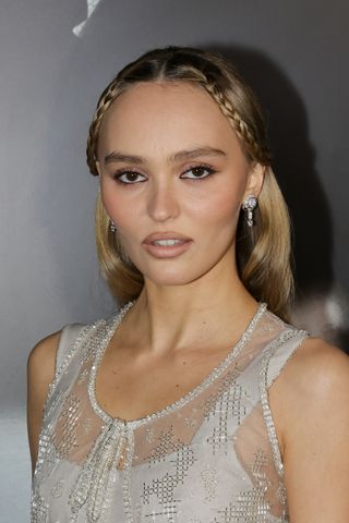 A photo of Lily-Rose Depp wearing pink and beige shades on her eyes, lips, and cheeks at the Los Angeles premiere of Nosferatu.