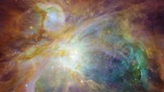 A Hubble Space Telescope image of the Orion Nebula shows swirling clouds of orange, blue, white and green dust in a field of twinkling stars