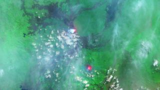 A satellite photo showing two bright red spots in a green landscape