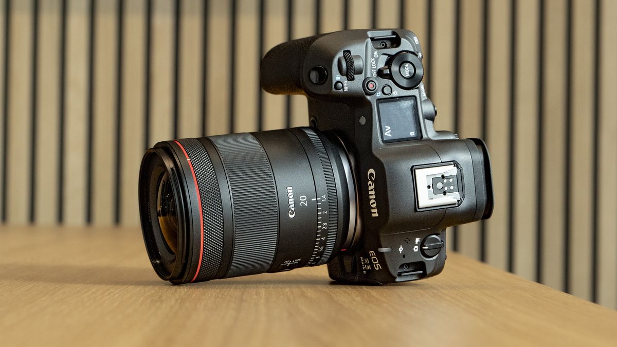 Canon RF 20mm F1.4L VCM lens on a wooden table, attached to the EOS R5 Mark II camera
