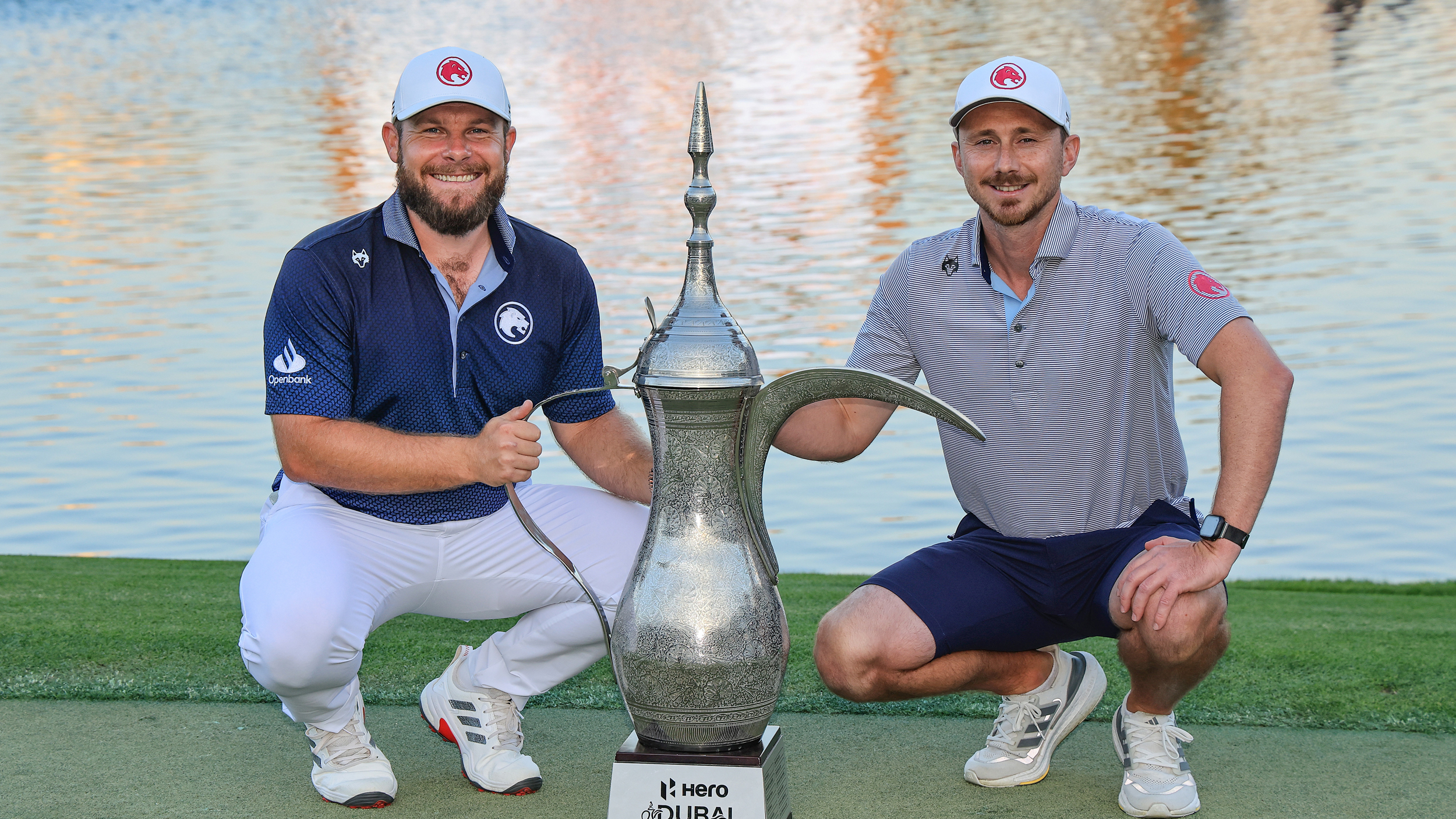Tyrrell Hatton (left) and his caddie Hugo Dobson pose next to the Dubai Desert Classic trophy after their win in 2025
