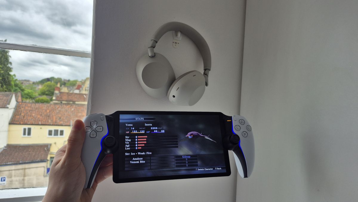 Man holding up PS Portal next to Sony WH-1000XM6 headphones while playing Shin Megami Tensei III: Nocturne