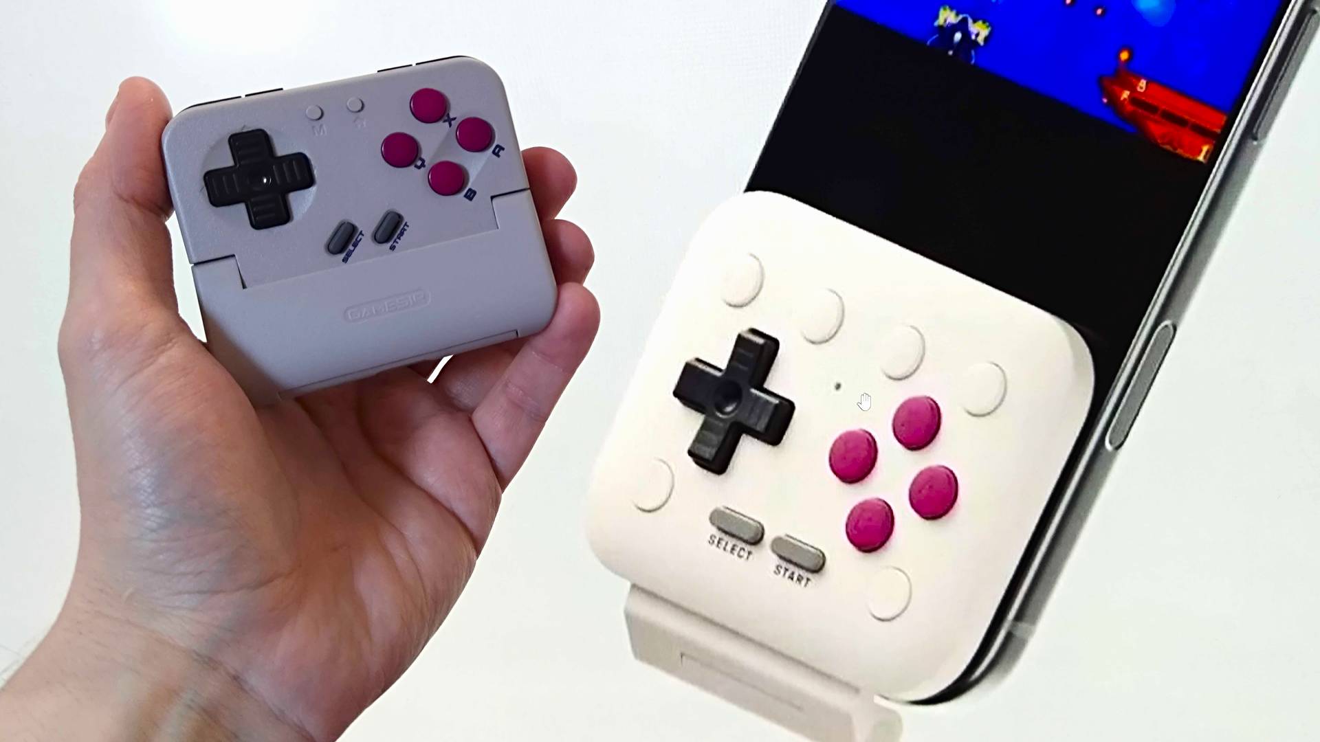 Close up of 8Bitdo FlipPad on right attached to phone next to hand holding Gamesir Pocket Taco on left.