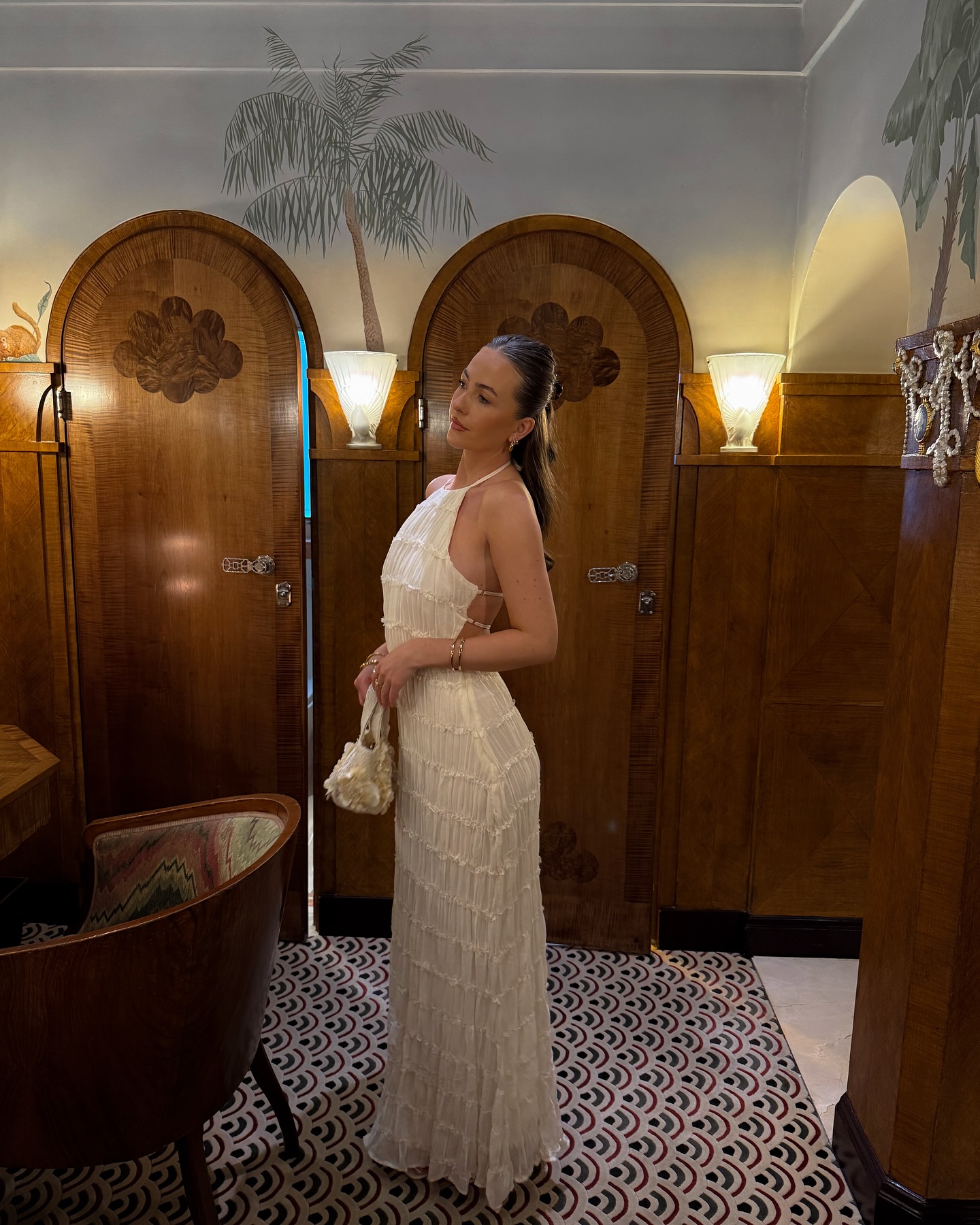 An image of @yesitsnicolee wearing a white halterneck dress while in London.