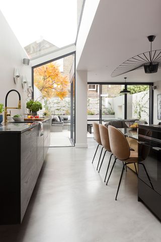 A kitchen with a glazed sloping roof and sliding doors leading to the garden