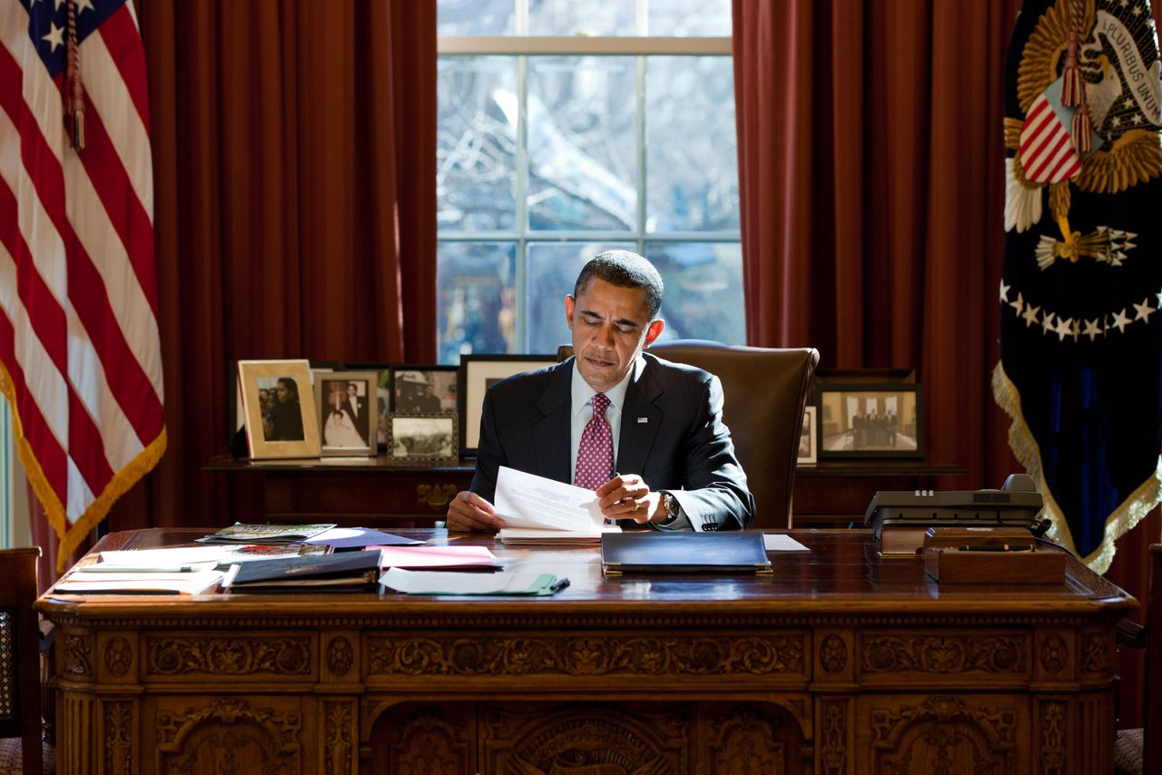 President Obama sits in the Oval Office.