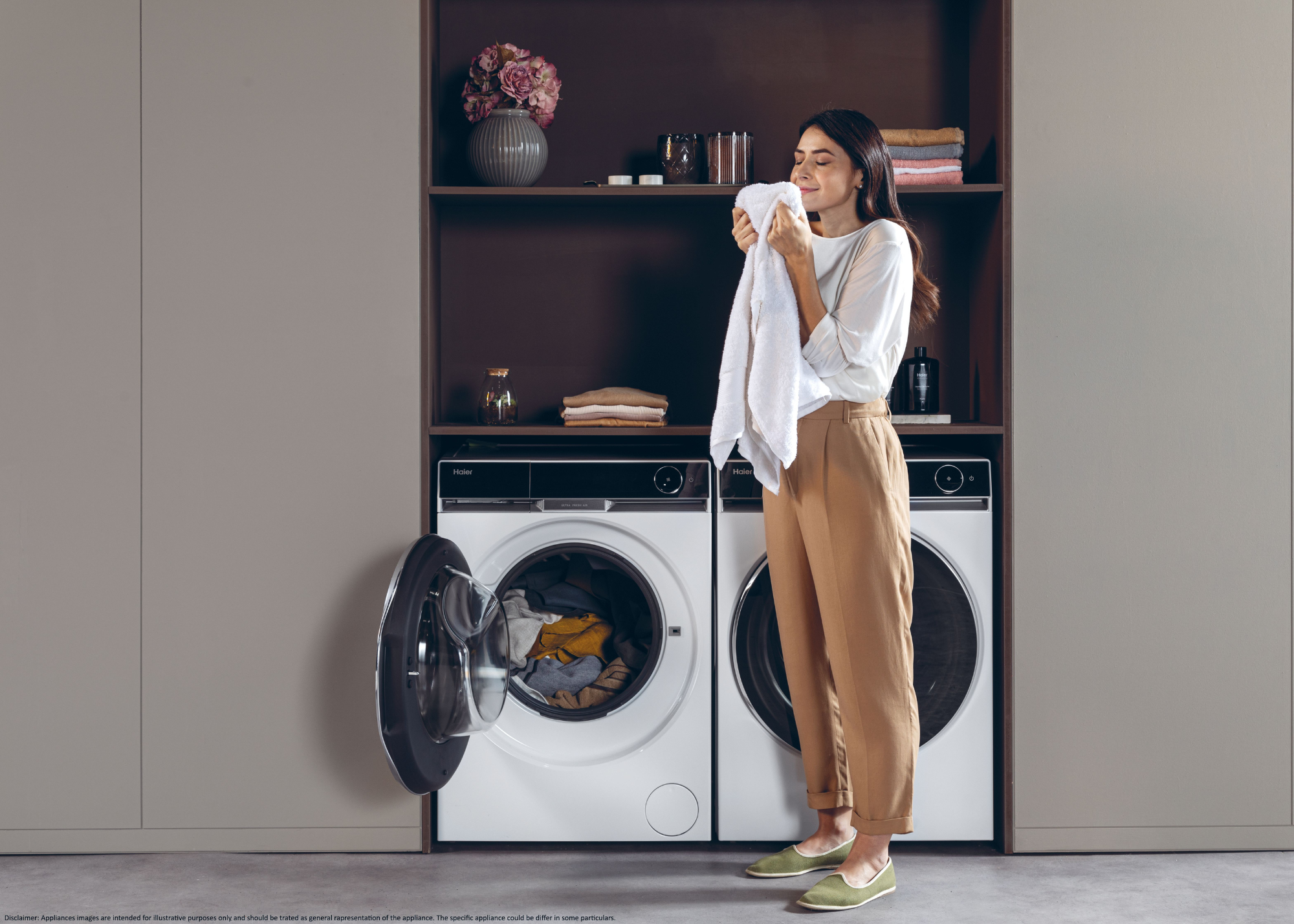 A woman smelling freshly cleaned clothes from the washing machine