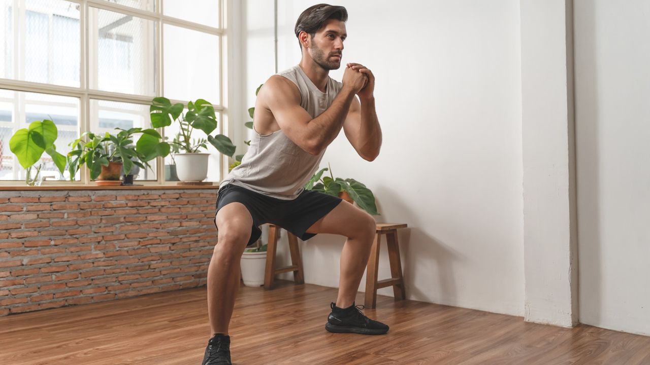 A man performing a sumo squat at home