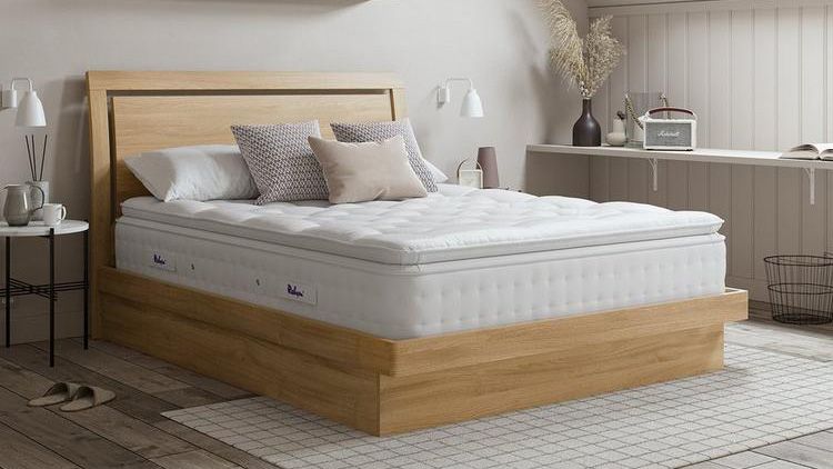 The Relyon Bridgwater Dunlopillo Latex Mattress photographed on a wooden bed frame in a natural looking bedroom with pampas grass in the corner