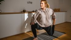 Woman doing yoga quad stretch at home