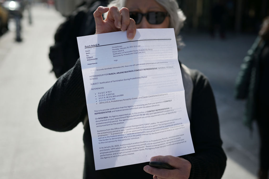 Arlen Rusch, a former Internal Revenue Service worker, shows the notice and leaves her office after being laid off in downtown Denver, Colorado on Thursday, February 20, 2025. The IRS began laying off roughly 6,000 employees in the middle of tax season as the Trump administration via the Department of Government Efficiency (DOGE) works to downsize the federal workforce. (Photo by Hyoung Chang/The Denver Post)