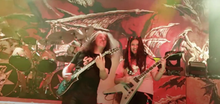 Maya Neelakantan playing guitar on stage with Testament