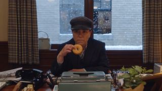 Alex Borstein as Susie holding a donut