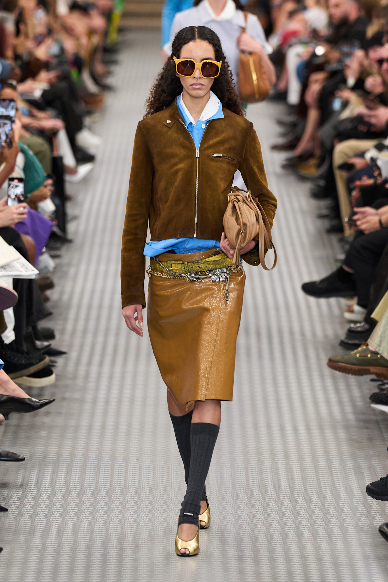 A woman walking down the runway wearing a miu miu outfit