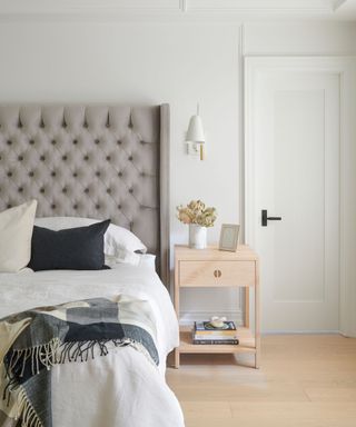 hotel style neutral bedroom with a checkered throw and decorative pillows