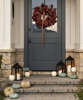 mcgee and co fall porch decor with teal pumpkins and a red leaf wreath