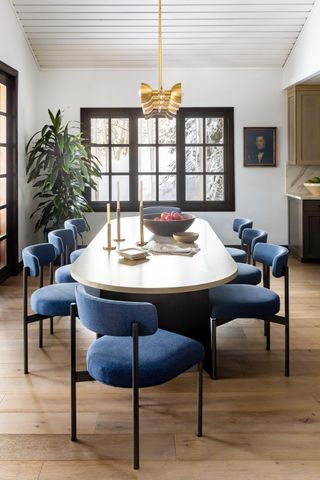 A dining area with a large oval table and blue chairs