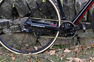 Andy Nicholl's black and red Orbea Hill Climb bike lent up against a small stone wall