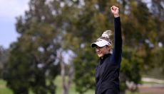 Nelly Korda raises her fist in the air after holing a birdie putt to win