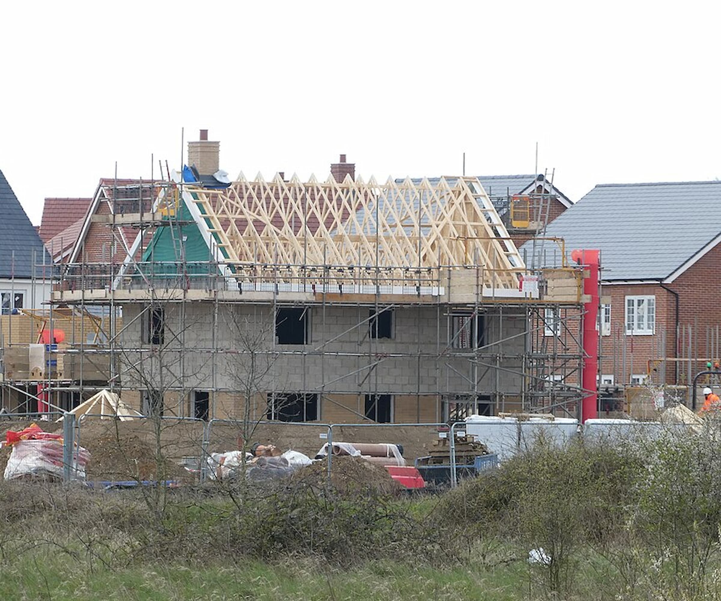 A house being built with a wooden frame and scaffolding around