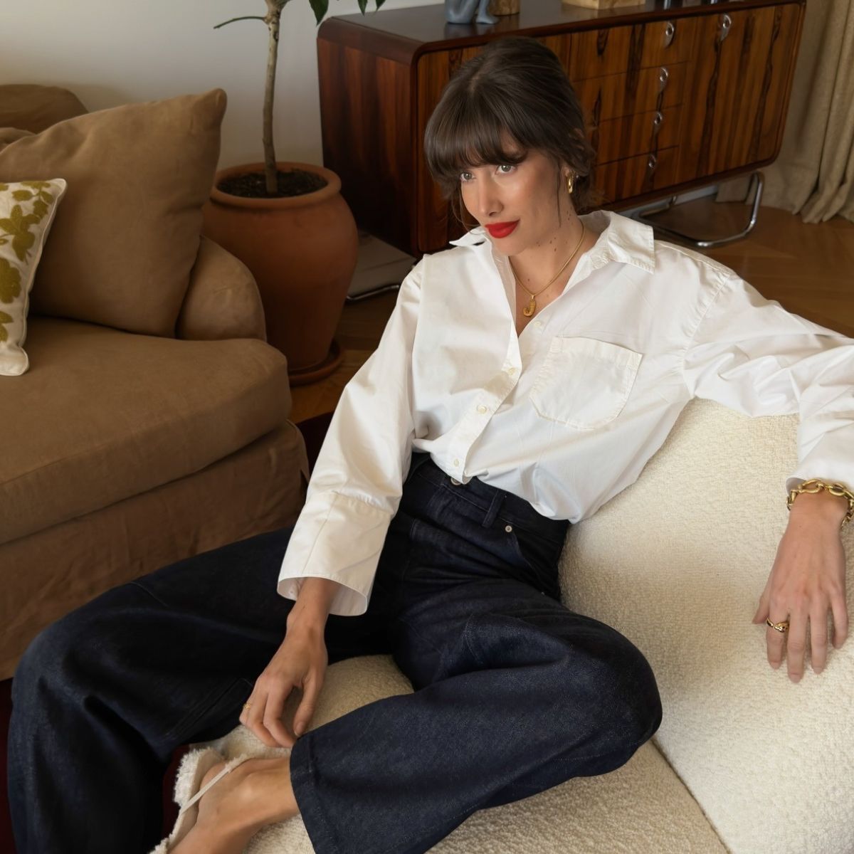 French influencer Julie Sergent Ferreri wearing blue jeans and a white shirt paired with a red lip and updo hairstyle