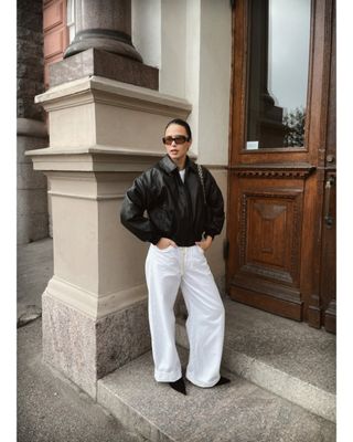 fashion influencer Johanna Piispa wearing a black bomber jacket with cuffed white jeans