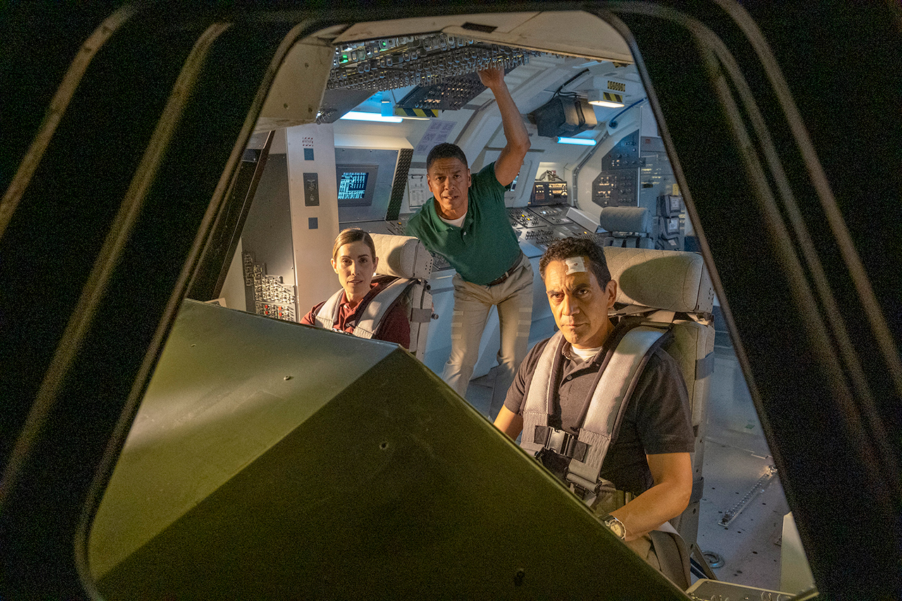 Samantha Stratton (Carly Pope, left), Jim Reynolds (José Zúñiga, right) and Max Everett (Leith Burke) on the space shuttle flight deck in the 