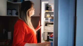 Women looks in the fridge for something to eat