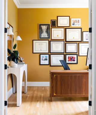 Yellow home office with gallery wall