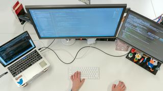 female software developer working across three machines