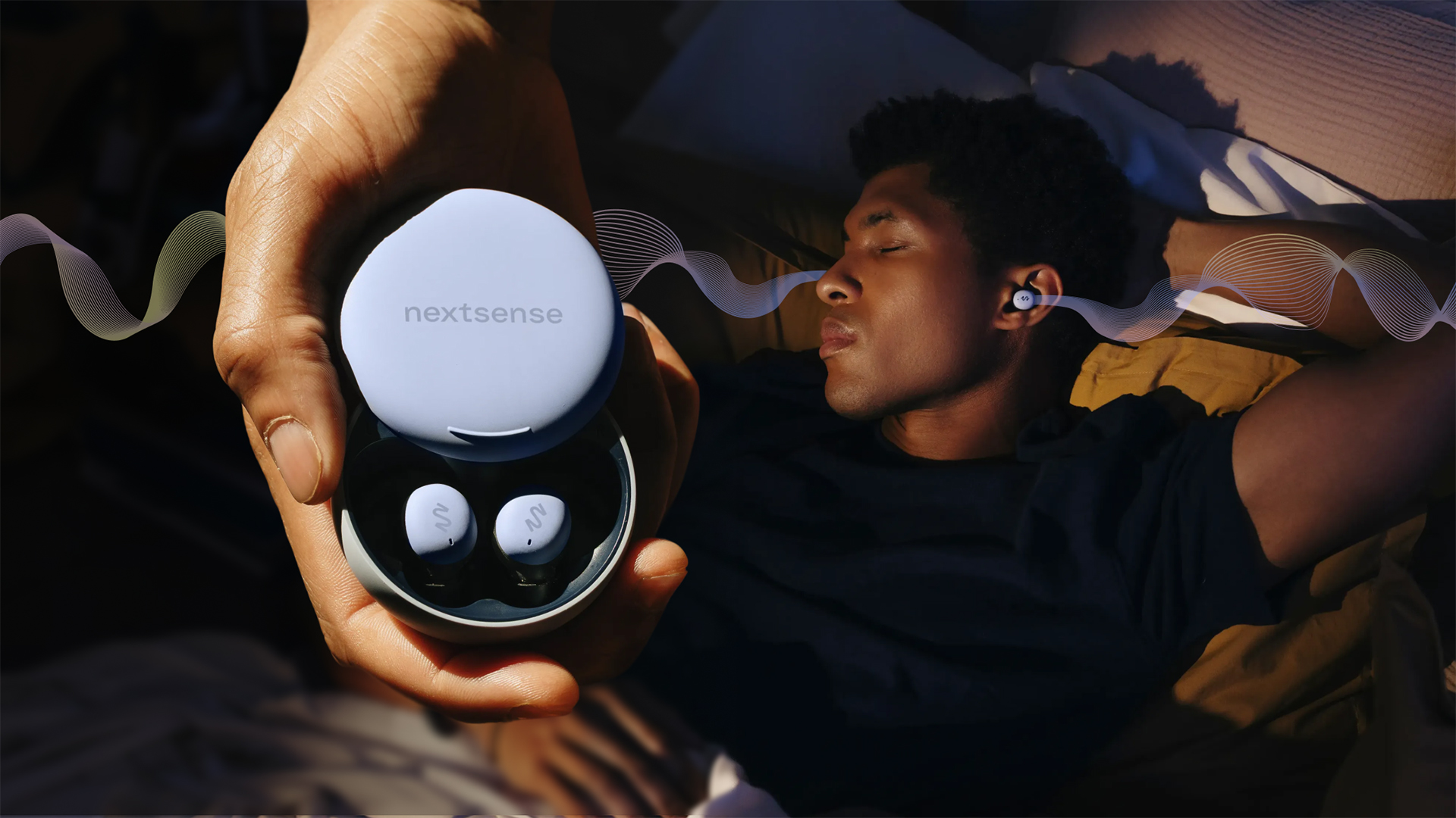 A man lies in bed on his back with his hands behind his head, wearing a pair of NextSense Smartbuds, with a line graphic demonstrating the EEG/ audio stimulation. POn the left, a close up of a hand holding the Smartbuds in their case.