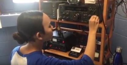 Lea Medina operates a radio.