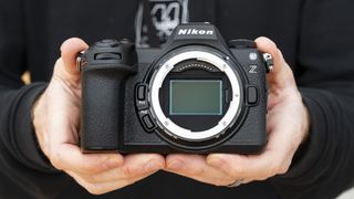 Nikon Z6 III camera in the hand with no lens attached and full-frame sensor on display