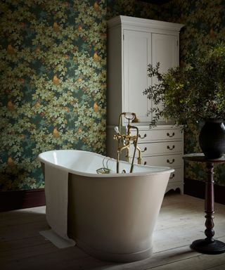 Floral wallpaper on walls of large bathroom with freestanding bath in center