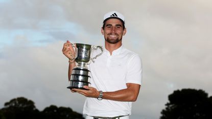 Joaquin Niemann smiles at the camera while holding up his 2023 Australian Open trophy