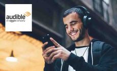 The audible logo over someone listening to an audiobook