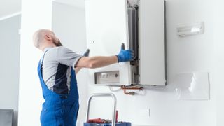 plumber removing front cover of boiler