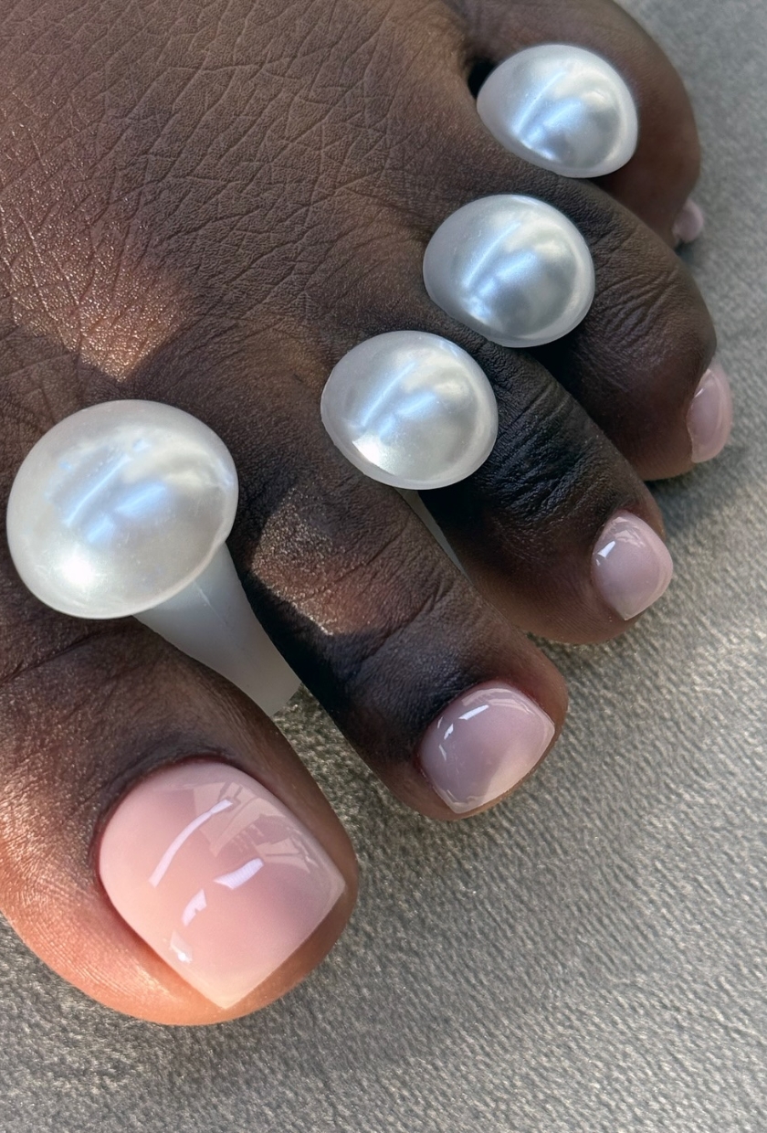 a close-up shot of a light pink pedicure