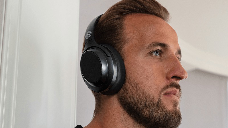 Harry Kane wearing a pair of Our Pure Planet black wireless headphones