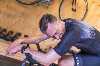 Male cyclist completing a hard interval session indoors