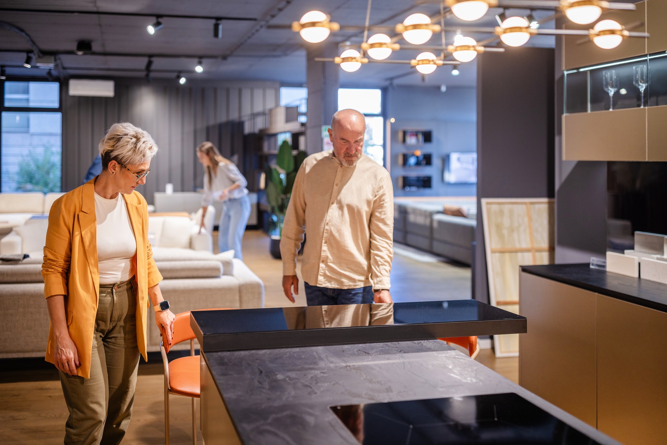 An older couple considers kitchen cabinets and counters at a design store.