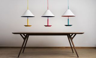 ’Little Eliah’ pendant lamps. Three pedant lamps above a wooden table.