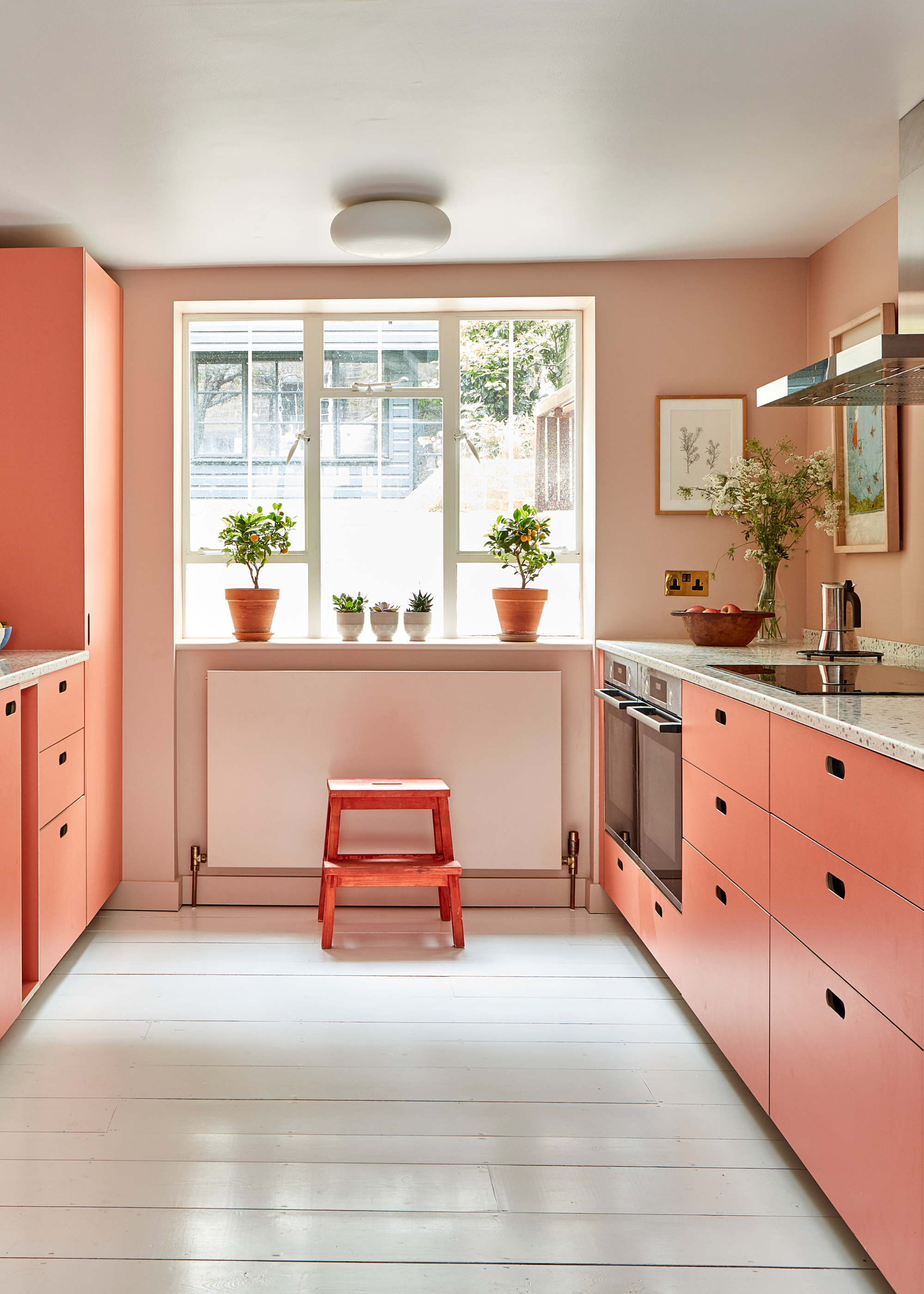 peach toned kitchen with color capping, and white wooden floors